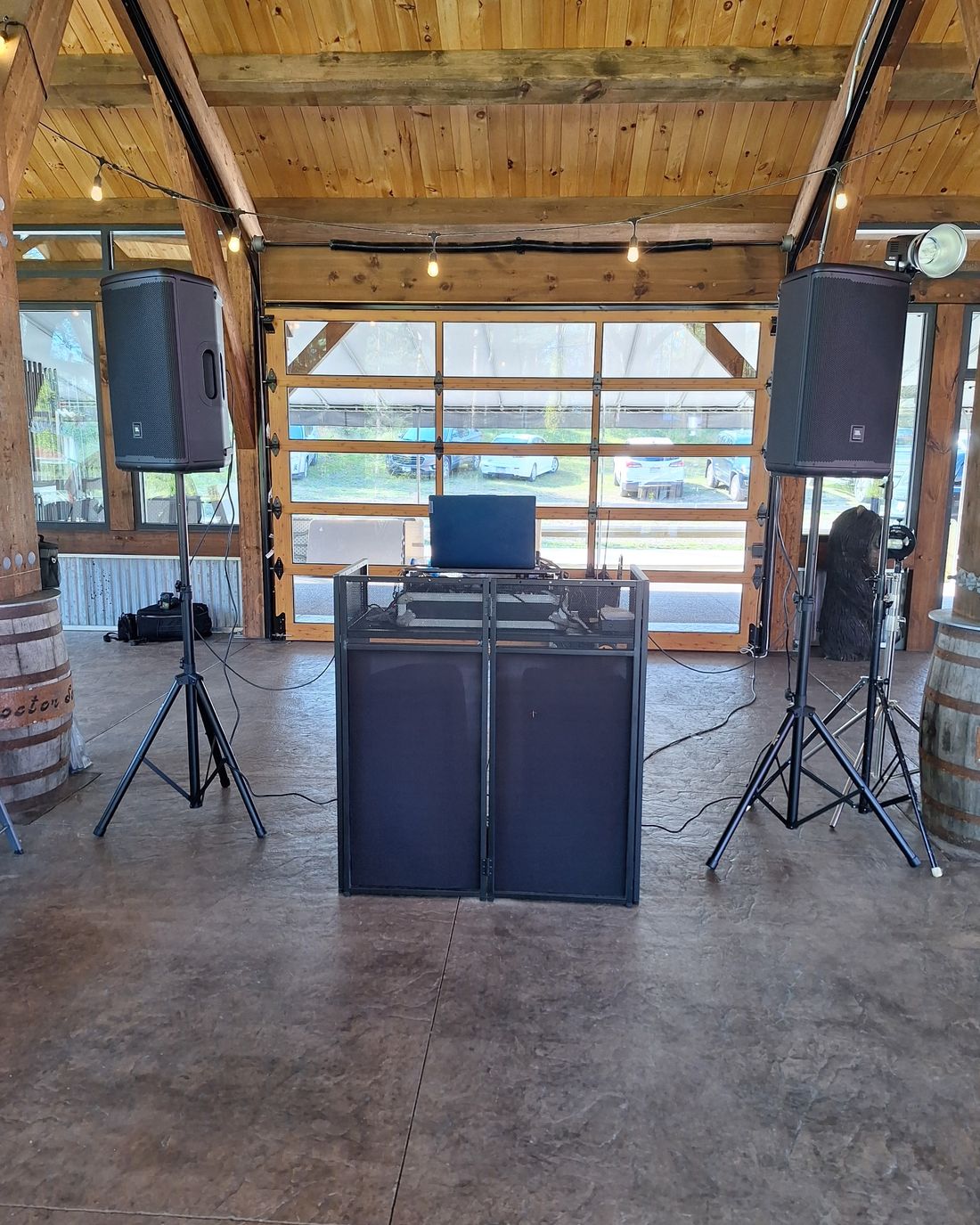BillyO's karaoke rig — pro speakers and DJ booth set up in a timber-frame event venue